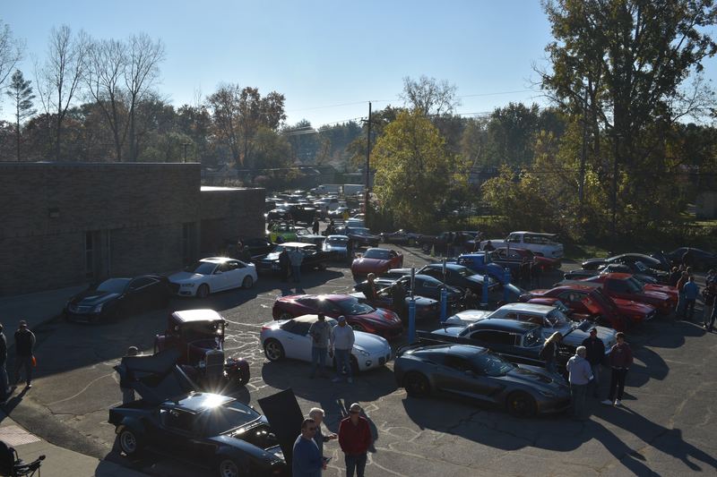 Cars and visitors filling the lot under a clear morning sky.