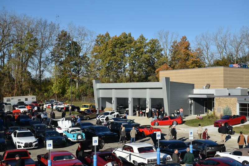 The full lot in front of the M-15 Motor Club building, packed with cars and people.