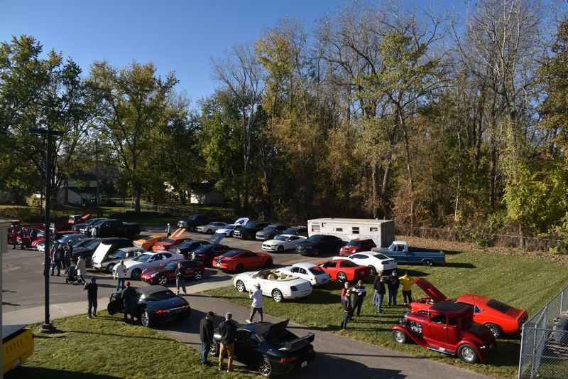 Cars and visitors on the lawn beside the building.