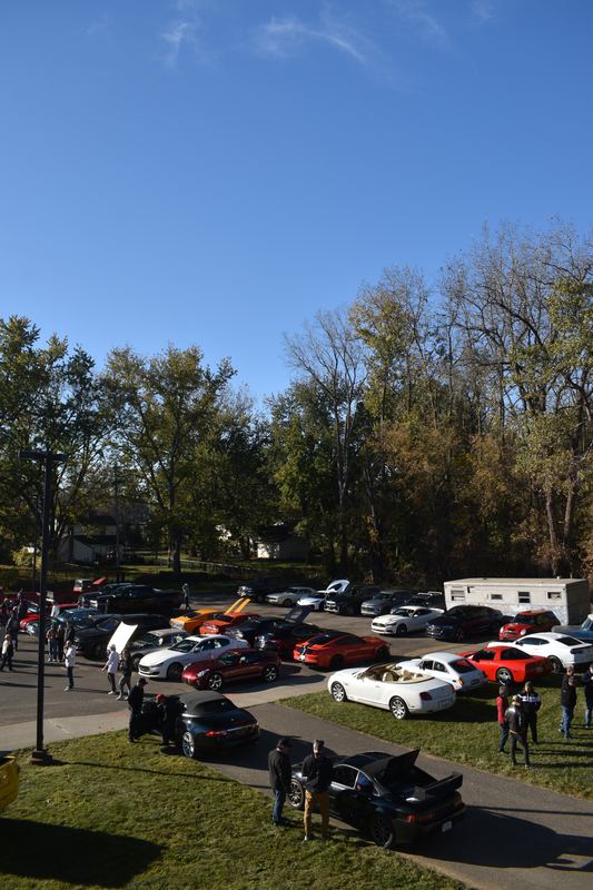 Cars lined up along the walkway and lawn.