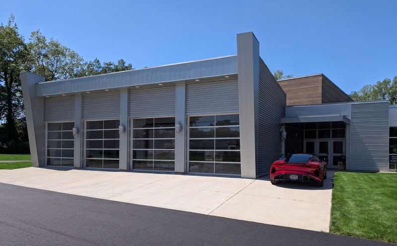 The four-door glass entrance with a red sports car parked at the door.