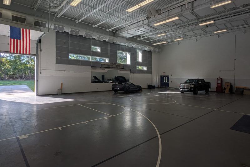 The Paddock: a large heated indoor space with member cars parked inside.