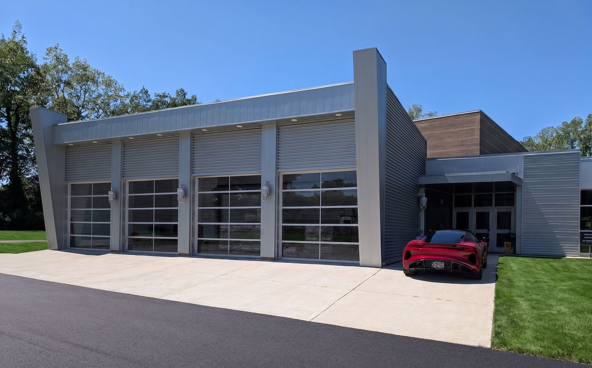 The four-door glass entrance at 155 E. Glass Rd., Ortonville, Michigan, with a red sports car parked at the door.