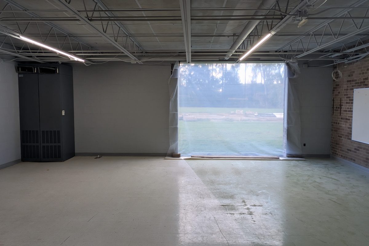 An empty garage suite with its new door opening cut into the far wall.